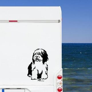 Schwarzer Bobtail Aufkleber auf einem weißen Wohnmobil am Meer unter blauem Himmel – wetterfestes Wohnmobil-Aufkleber-Motiv von amberdog