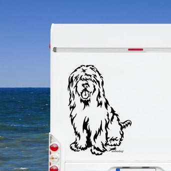 Schwarzer sitzender Briard Aufkleber am weißen Wohnmobil-Heck vor Meereskulisse – wetterfestes Wandtattoo- und Autoaufkleber-Motiv von amberdog