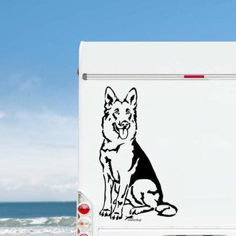 Schwarzer sitzender Deutscher Schäferhund Aufkleber am weißen Wohnmobil-Heck vor Meereskulisse – wetterfestes Wandtattoo- und Autoaufkleber-Motiv von amberdog