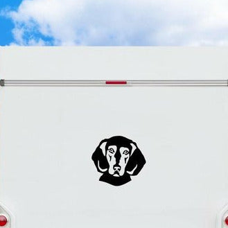 Schwarzes Griechische Bracke Kopf-Motiv als Aufkleber auf der weißen Rückwand eines Wohnmobils vor blauem Himmel, wetterfestes Autoaufkleber-Motiv von amberdog
