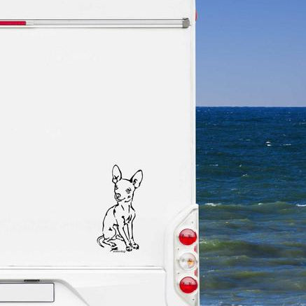 Schwarzer Prager Rattler Aufkleber auf einem weißen Wohnmobil am Meer unter blauem Himmel – wetterfestes Wohnmobil-Aufkleber-Motiv von amberdog