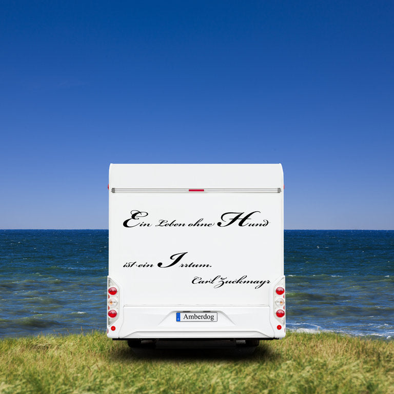 Wohnmobil-Heck mit schwarzem Aufkleber „Ein Leben ohne Hund ist ein Irrtum“ am Meer | amberdog®