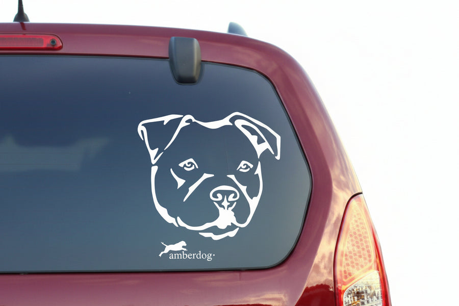 Weißer Pitbull Kopf Aufkleber auf der Heckscheibe eines dunkelroten Autos – wetterfestes Autoaufkleber-Motiv von amberdog